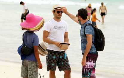 <p><strong>POST-PANDEMIC RECOVERY.</strong> A foreigner tries on hat in Boracay Island, one of the country's top tourist destinations in this undated photo. BMI sees tourist arrivals in the Philippines to surpass the pre-pandemic level by 2025. <em>(PNA file photo)</em></p>